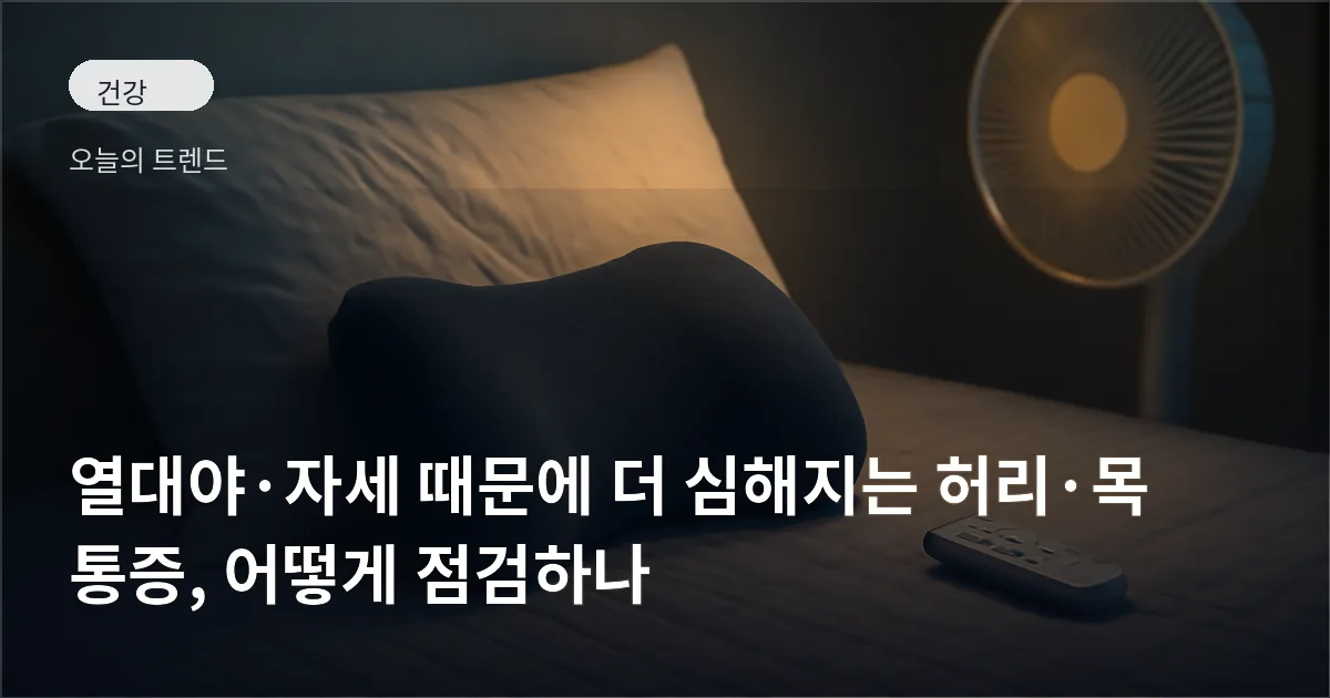 얕은 조명 아래 침대 위에 놓인 베개와 허리 지지 쿠션, 옆에 선풍기 리모컨이 놓여 있는 장면